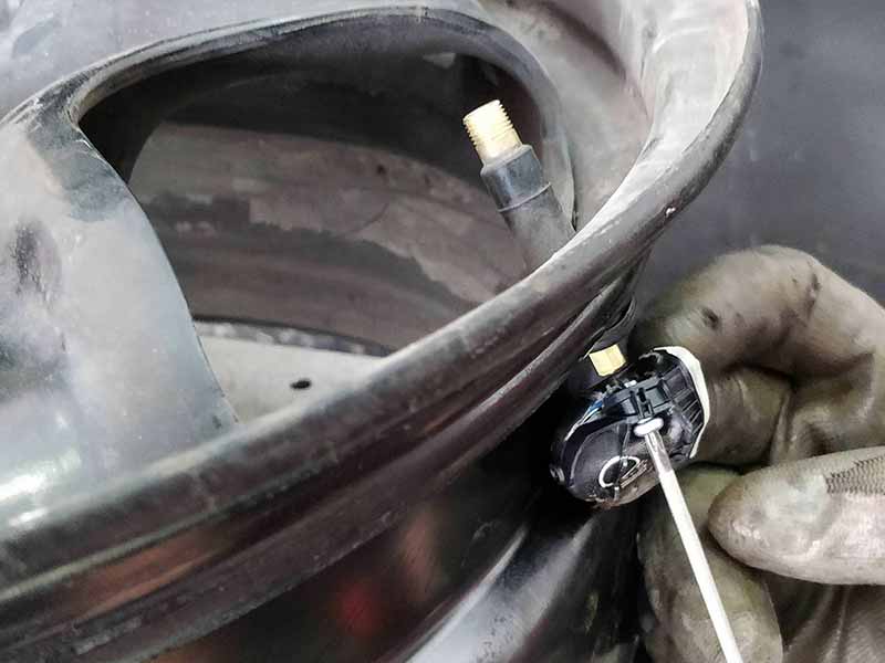 tire pressure sensor being removed from wheel