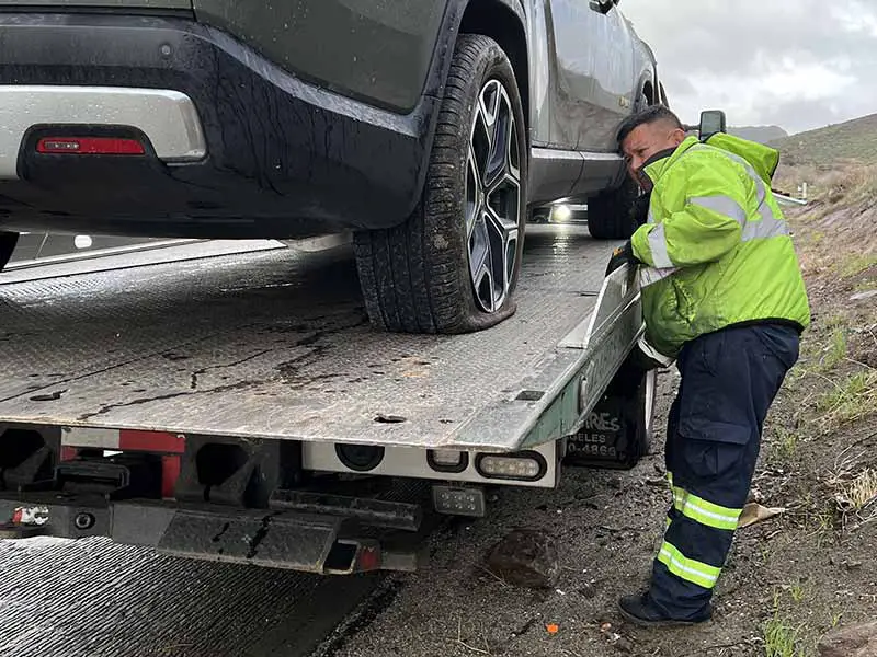 Truck With Flat Tire Being Towed On A Flatbed Tow Truck